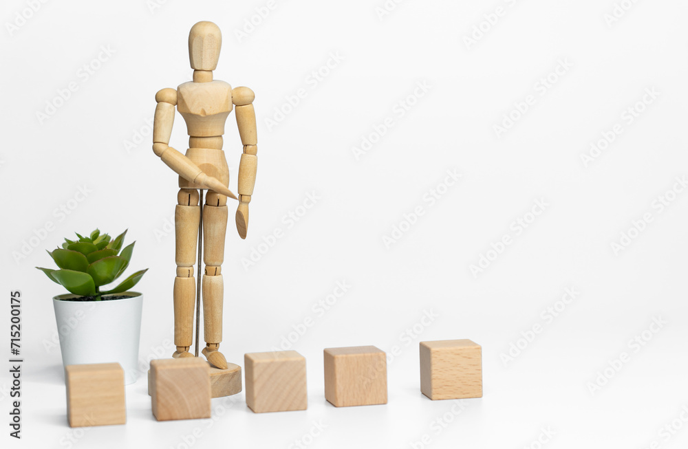 Wooden doll with wooden toy block isolated on white background. business or creative concept Wooden doll with wooden toy block isolated on white background. business or creative concept