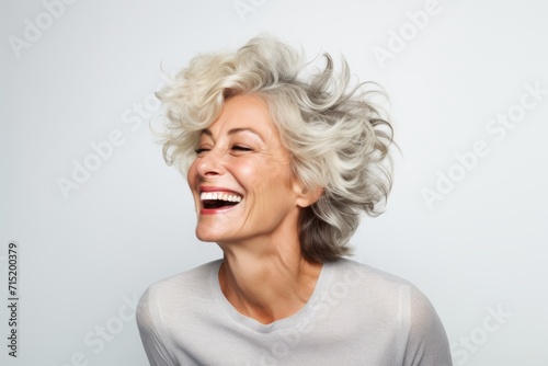 Portrait of a beautiful middle-aged woman laughing against white background