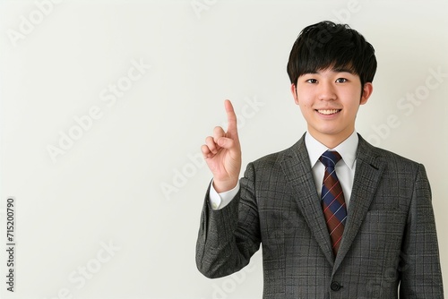 指をさす日本人の男性ビジネスマンマンのポートレート写真（白背景・会社員・スーツ・新入社員・窓口・案内）