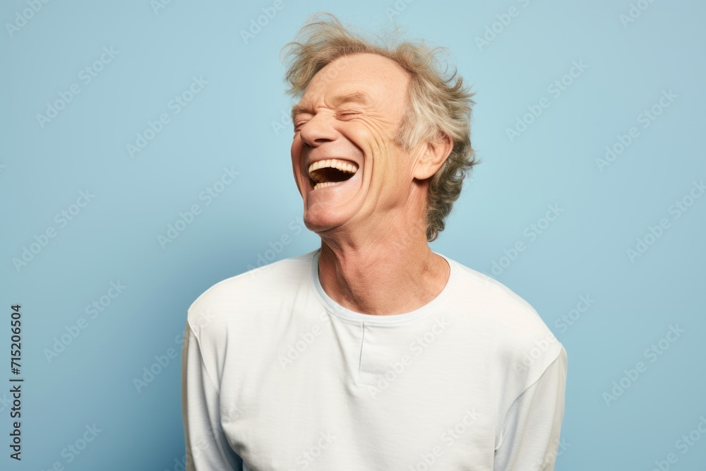 Portrait of a happy senior man laughing isolated over blue background. Portrait of a happy senior man laughing isolated over blue background.
