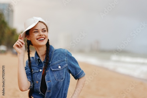 Cheerful Young Woman in Elegant Hat, Enjoying Summer Vacation on a Bright Blue Sky, Relaxing by the Ocean © SHOTPRIME STUDIO