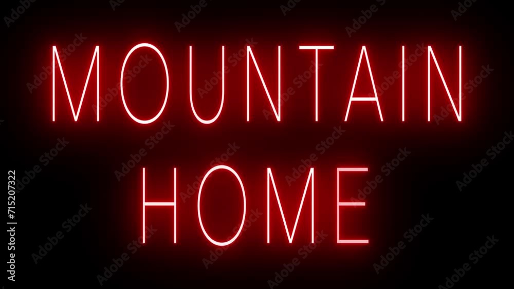 Flickering red retro style neon sign glowing against a black background for MOUNTAIN HOME
