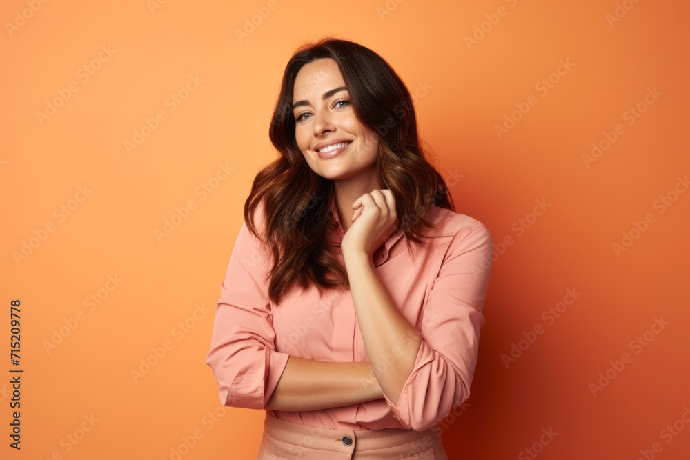 Portrait of smiling business woman in pink blouse on orange background Portrait of smiling business woman in pink blouse on orange background