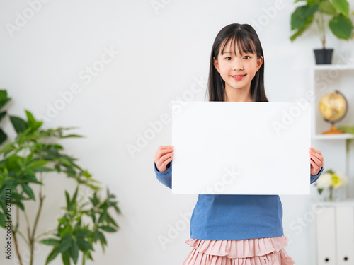 白紙のメッセージボードを見せる女の子 photo