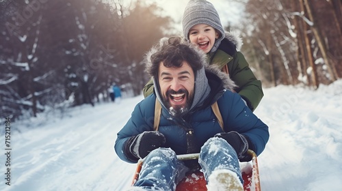 A man and his son tobogganing down a snowy hill , man, son, tobogganing, snowy hill photo