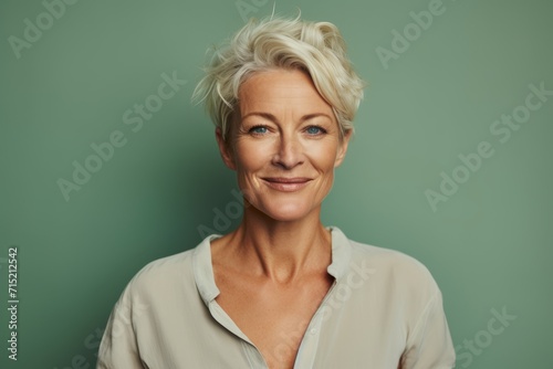Portrait of smiling mature businesswoman looking at camera against green background