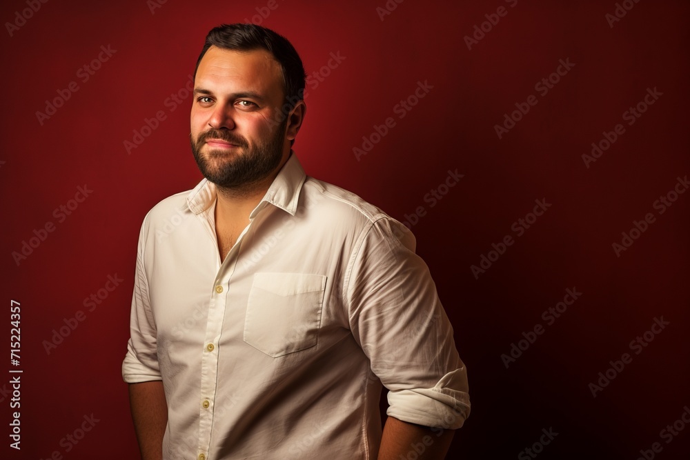 Portrait of a handsome young man with beard on a red background