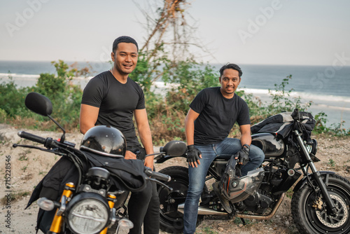 asian men rider sitting on motorbike while touring in countryside