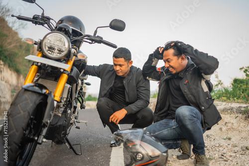 indonesian rider feeling frustrated because his motorbike broken