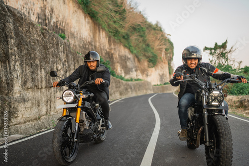 happy indonesian bikers traveling together by riding a motorcycle