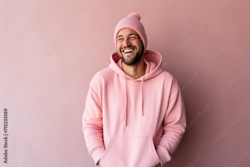Portrait of a smiling man in a pink hoodie and a pink hat. Portrait of a smiling man in a pink hoodie and a pink hat.