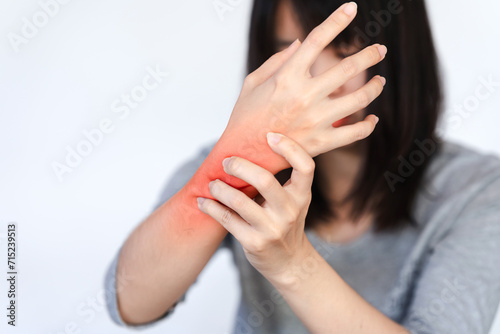 A woman's wrist is in pain and a red area is made to show the pain point. photo