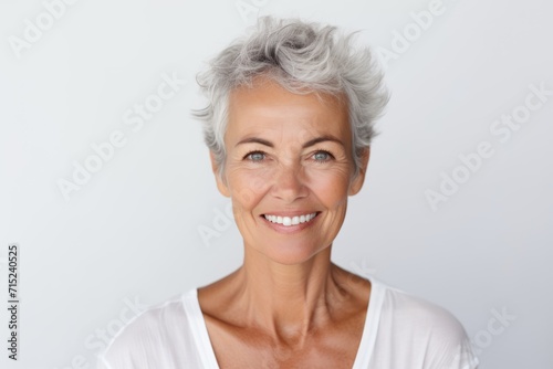 Portrait of a smiling senior woman with grey hair against white background