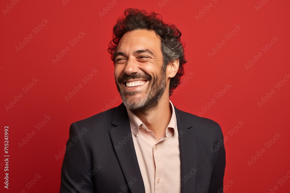 Portrait of a happy man laughing and looking at camera isolated over red background Portrait of a happy man laughing and looking at camera isolated over red background