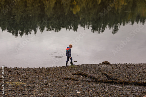 Child walking in nature mountain lake forest 