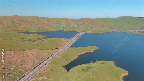 State Route 152 On San Luis Reservoir Surrounded With Lush Green Hills In California, USA. aerial shot photo