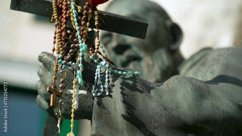 Statue of Saint Pio with rosaries draped over the Christian cross he holds in Atrani on the Italian Amalfi Coast. photo