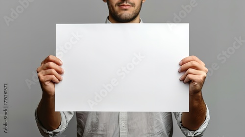 Man holding an empty sign board in clean backdrop with a big empty space, Generative AI. photo