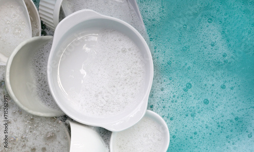 Plates and bowl soaking in foam of dishwashing liquid