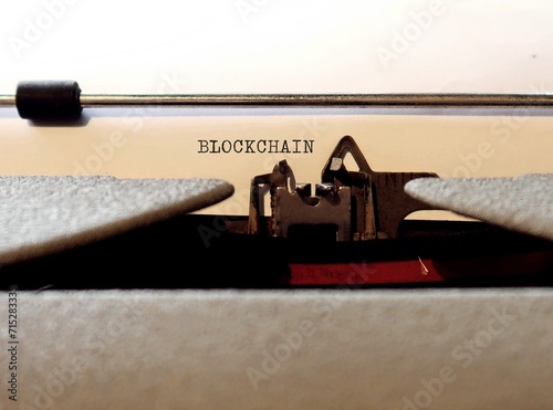 Old Vintage typewriter with text BLOCKCHAIN means technology system of recording information that makes it impossible to change, hack or cheat - enables the existence of cryptocurrency photo