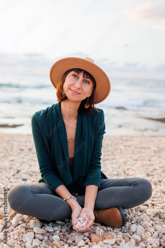 Beautiful natural beauty woman smiling and laughing, posing for the camera on the beach. Portrait of a young smiling girl in a hat,