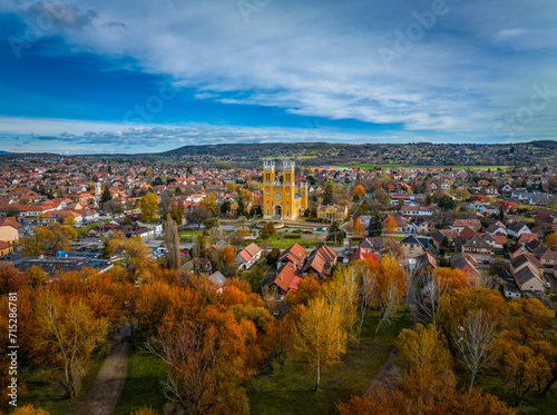 Fot, Hungary - Aerial view of the Roman Catholic Church of the Immaculate Conception (Szeplotlen Fogantatas templom) and the town of Fot on a sunny autumn day with autumn foliage and blue sky photo