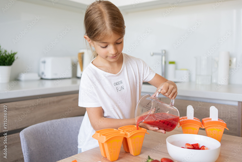 Child girl cooking berry popsicles at home