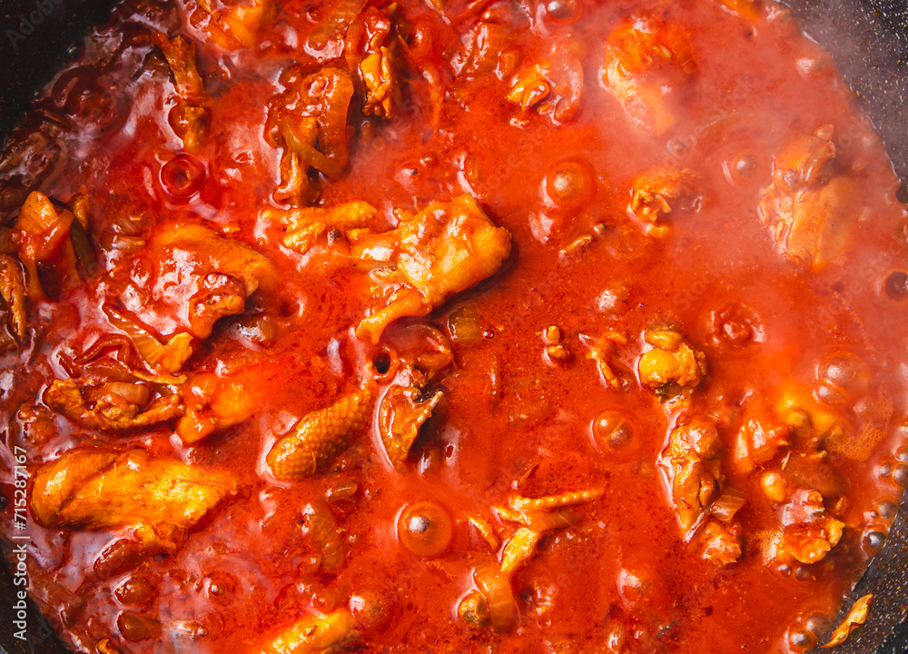 Chicken meat is stewed in tomato in a frying pan Chicken meat is stewed in tomato in a frying pan