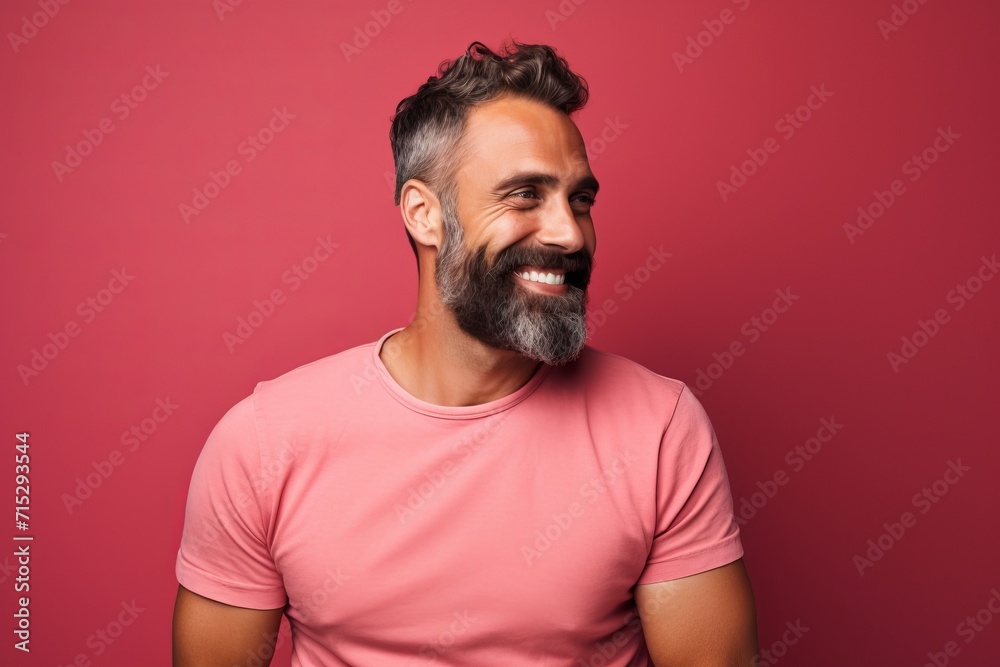 Portrait of a happy bearded man in a pink t-shirt on a red background Portrait of a happy bearded man in a pink t-shirt on a red background