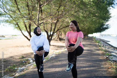 women in sportswear warming up together outdoors, healthy activity concept