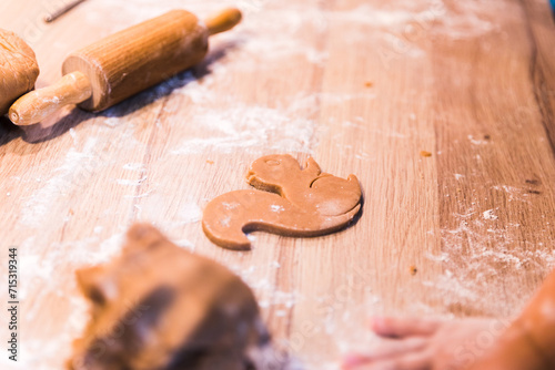 Close up hands kneading a dough on a wooden table.