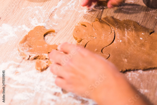 Close up hands kneading a dough on a wooden table.