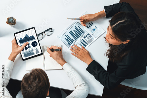 Top view Analyst team uses BI Fintech display tablet to analyze financial data. Business people analyze BI software technology dashboard power for insight power into marketing planning. Prudent