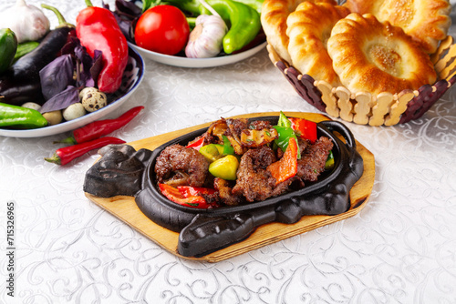 Fried beef meat with pepper in a frying pan. Eastern cuisine. Uzbek cuisine.