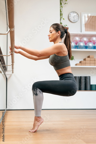 Fit woman doing rehearsal on barre in gym