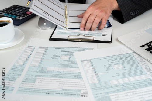 man completing tax form 1040. Tax time