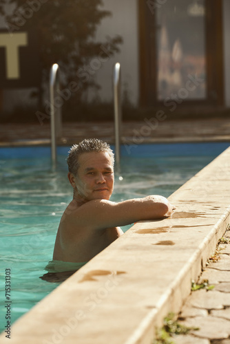 Asian man bathes in hot springs pool in cold weather photo