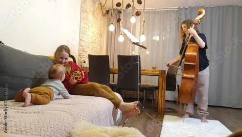 home rehearsal. girls play violin and double bass. Little first viewer photo