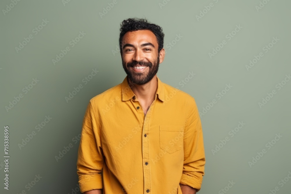 Portrait of a handsome Indian man smiling while standing against green background Portrait of a handsome Indian man smiling while standing against green background