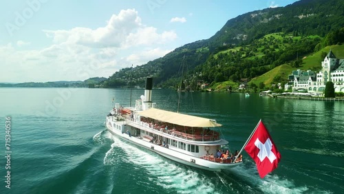 Aerial drone view of steamboat ship in Lake Lucerne. Swiss Flag. Beautiful Swiss Alps nature in summer Switzerland, 4k. Turquoise blue lake water. 