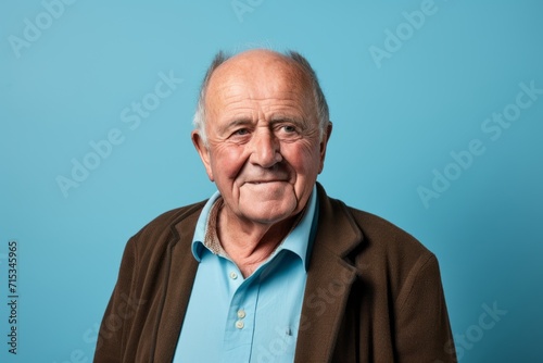 Portrait of an old man in a jacket on a blue background