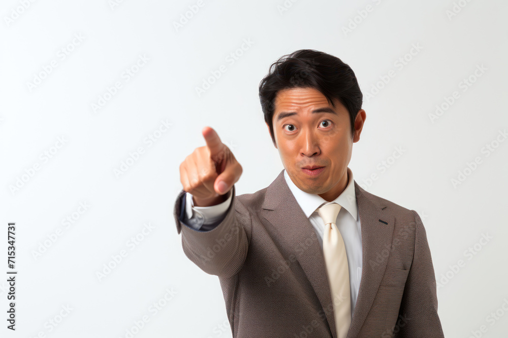 Photograph of a Japanese businessman in a serious pose pointing upwards, copy space above, against a light cream background
Photograph of a Japanese businessman in a serious pose pointing upwards, copy space above, against a light cream background