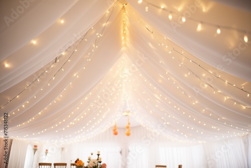 white drapery and fairy lights adorning the ceiling of a hall photo