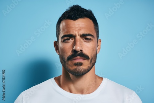Portrait of handsome man in white t-shirt on blue background