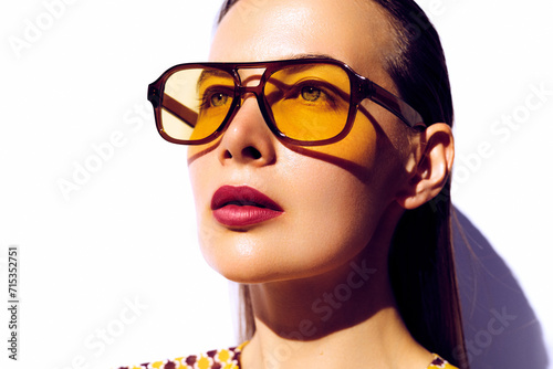 Fashion model portrait. Square shape yellow sunglasses. Young beautiful model posing in vintage style design eyeglasses against white background. Eye wear look book, campaign photo