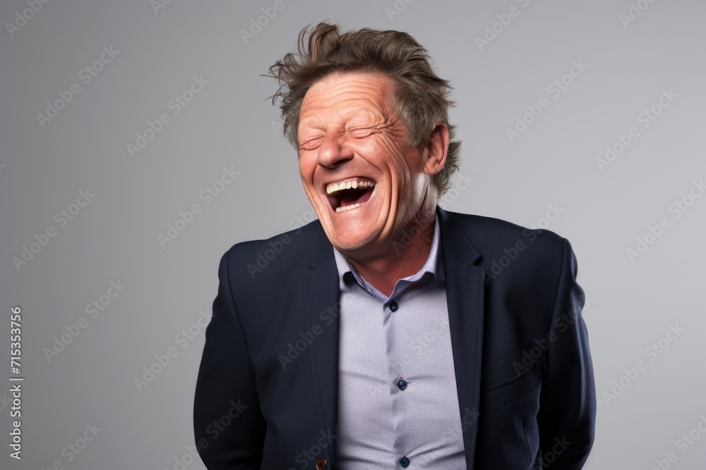 Laughing senior man over grey background. Looking at camera. Laughing senior man over grey background. Looking at camera.