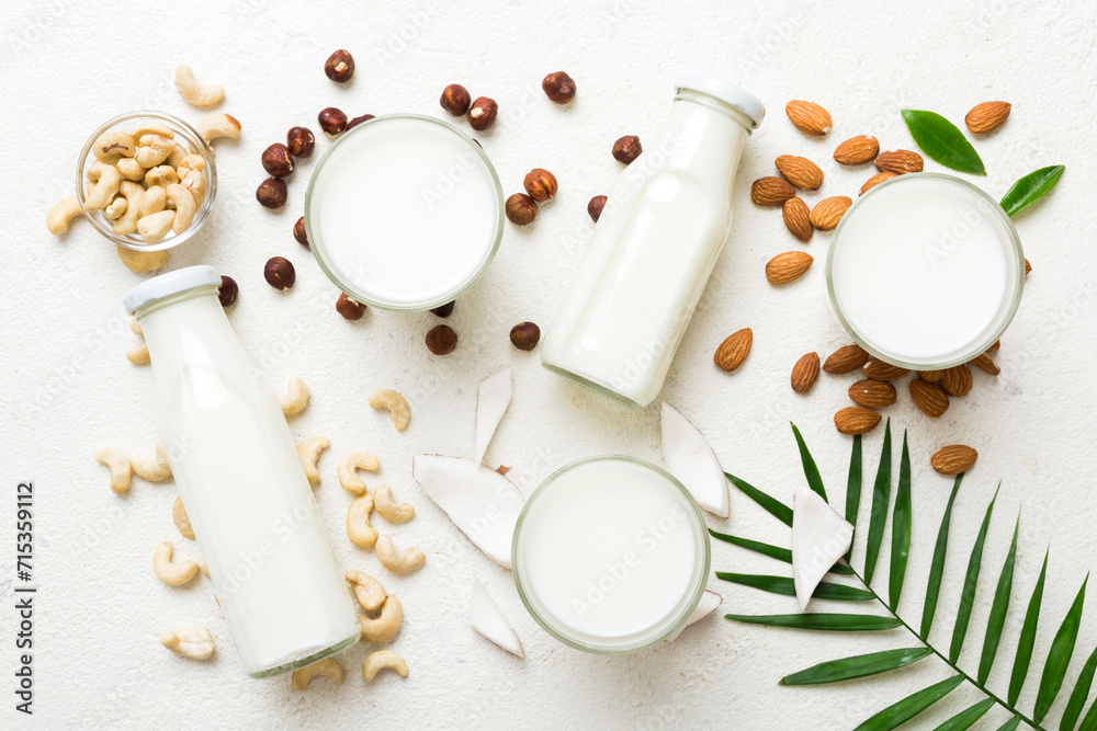 Set or collection of various vegan milk almond, coconut, cashew, on table background. Vegan plant based milk and ingredients, top view