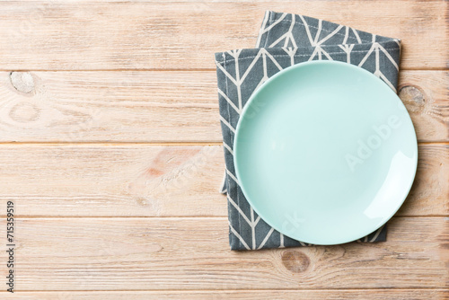 Top view on colored background empty round blue plate on tablecloth for food. Empty dish on napkin with space for your design photo