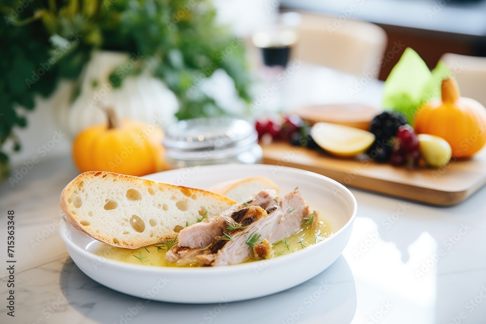 sliced baguette surrounding a bowl of duck confit pꋃ琀쌀©