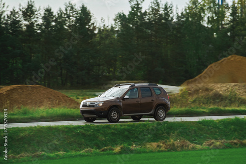 A modern family SUV car journeys along a scenic road with majestic nature and a golden sunset in the backdrop. Subcompact truck with more offroad capabilities and 4WD AWD 4x4 mode.